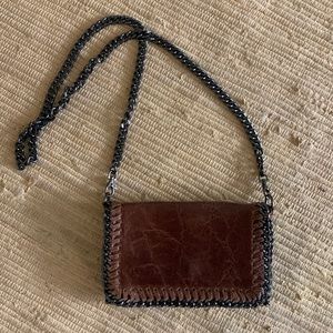 Brown leather crossbody clutch bag with gunmetal chain strap